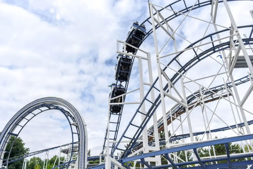 Steel roller coaster under blue skies at a theme park
